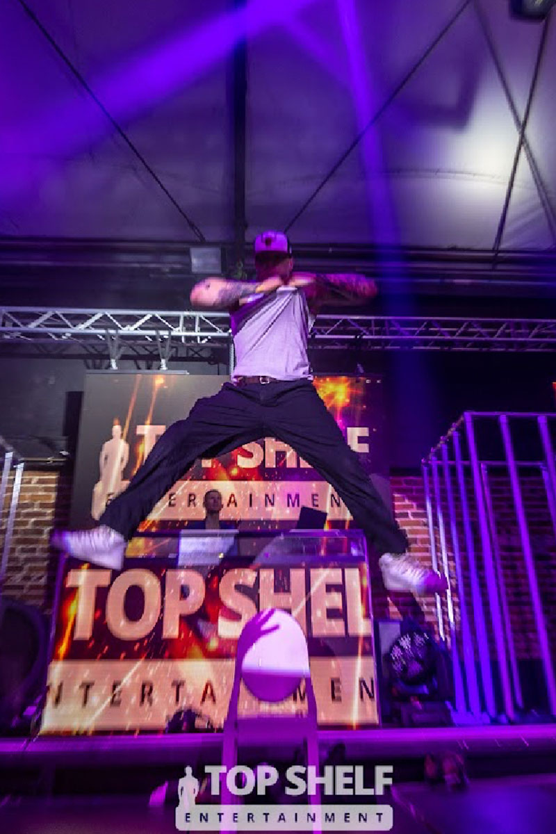 Top Shelf Male Entertainment on stage shot with logo